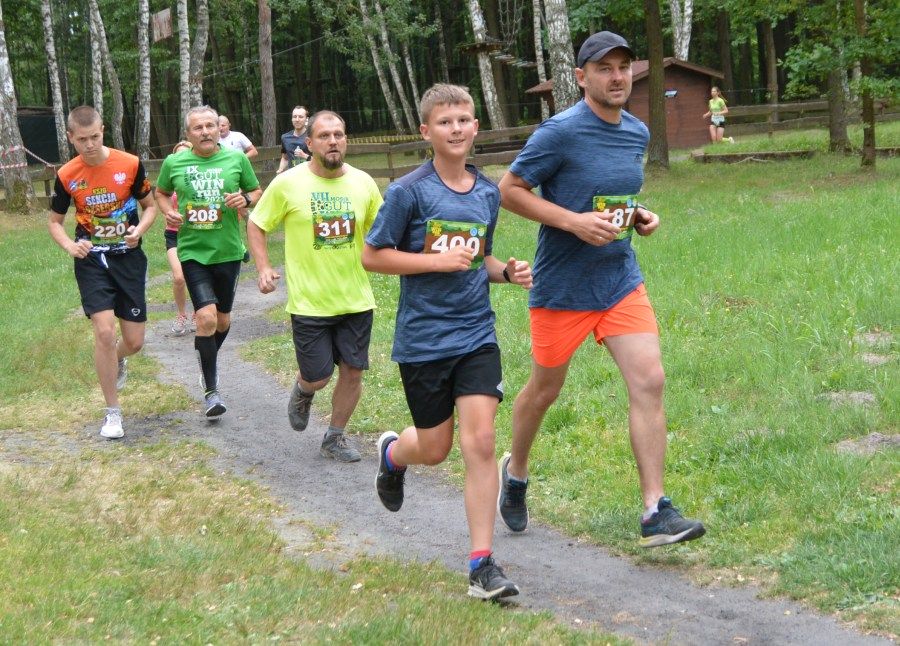 Marcin i Dawid Połowniakowie na czele grupy biegaczy na leśnym odcinku trasy.
